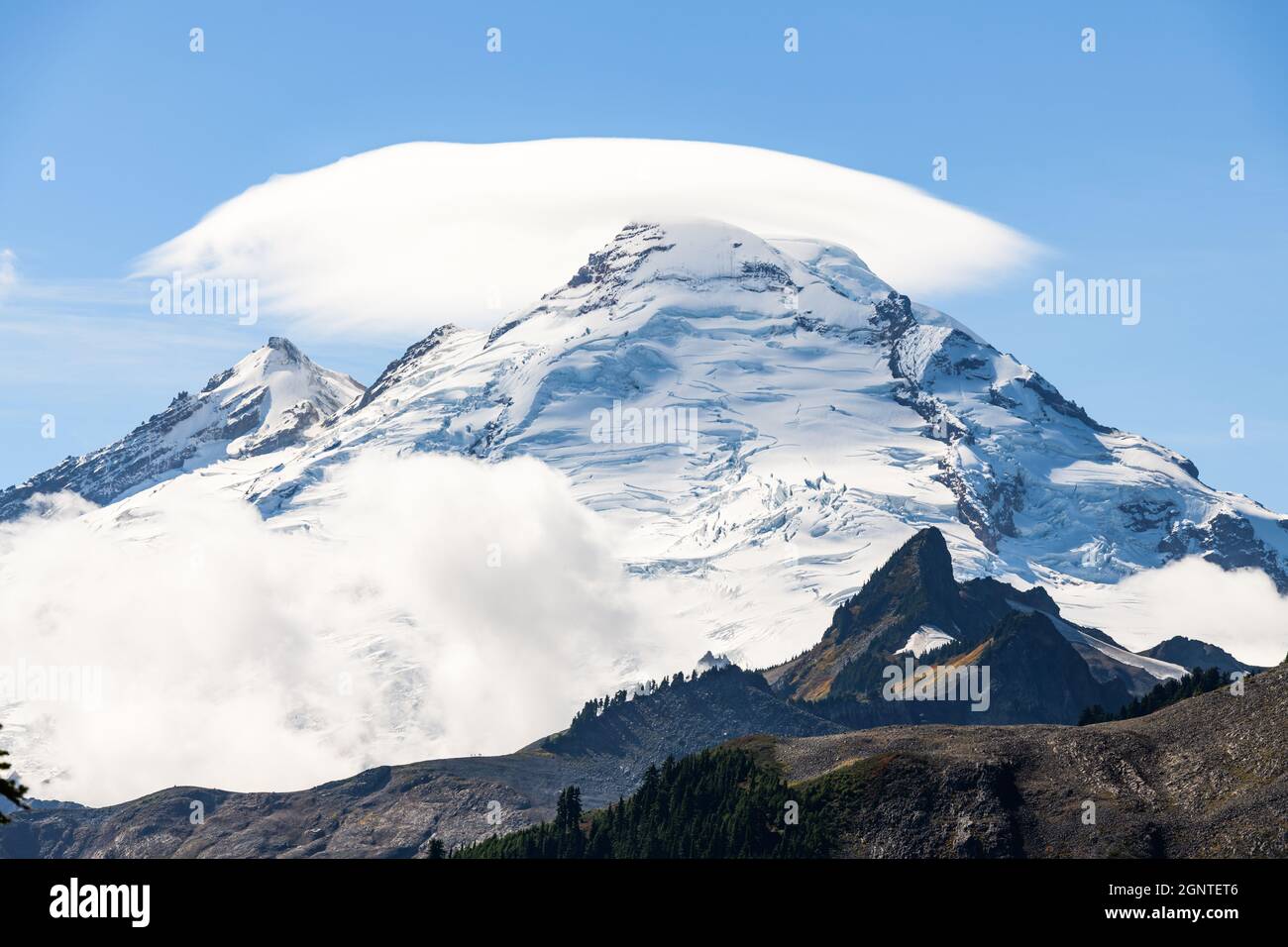 Un fenomeno meteorologico della nuvola si aggira sopra il picco glaciale del vulcano Mount Baker nello stato di Washington Foto Stock