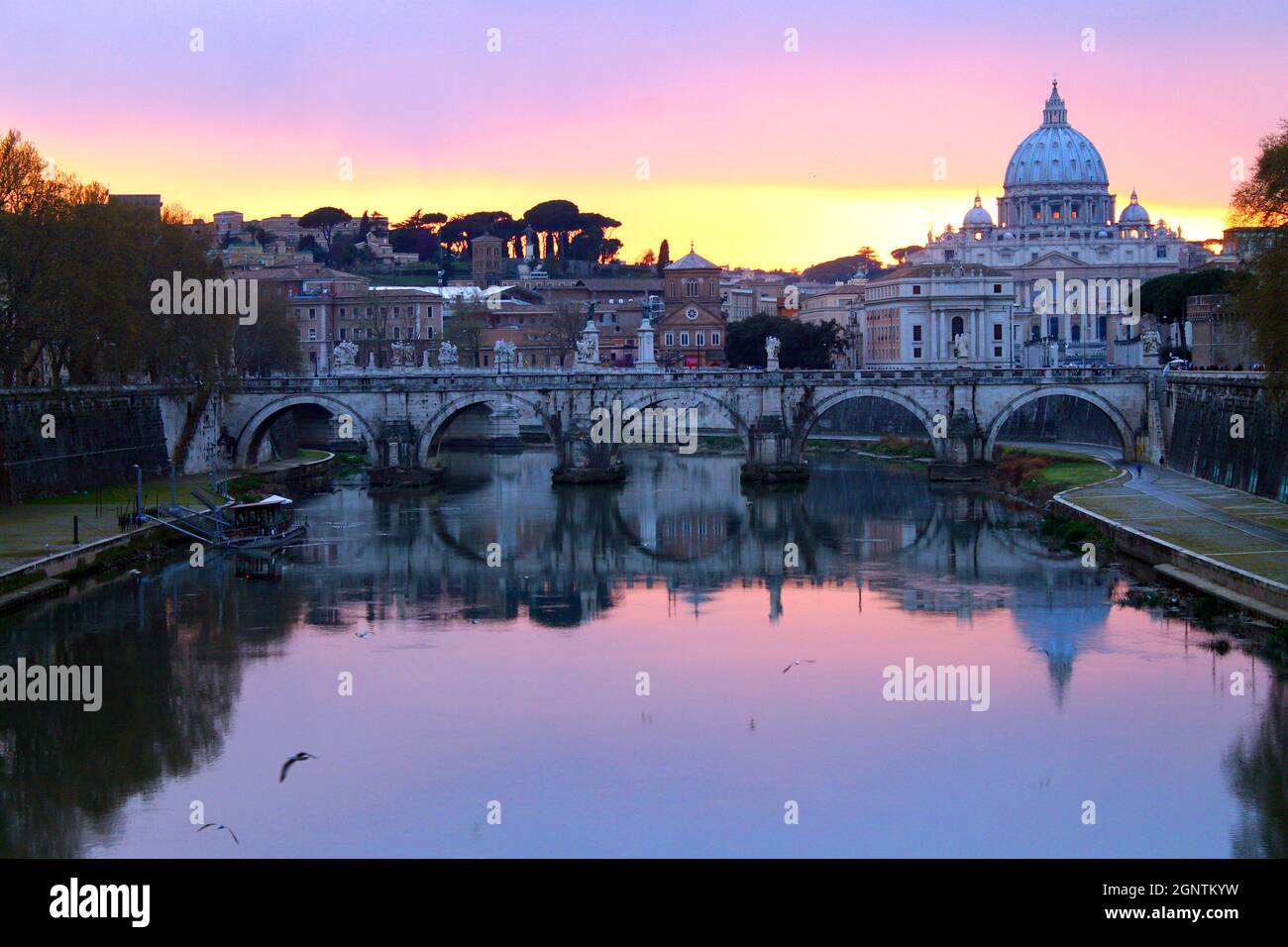 I colori del tramonto sul fiume con la Città del Vaticano sul retro a Roma Foto Stock