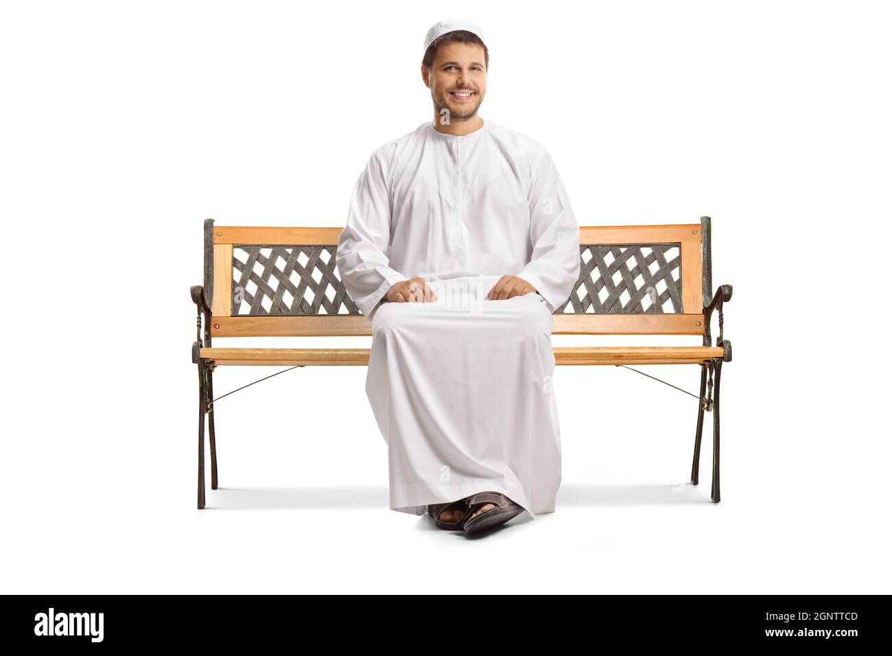 Giovane musulmano in abiti etnici seduti su una panca e sorridente isolato su sfondo bianco Foto Stock