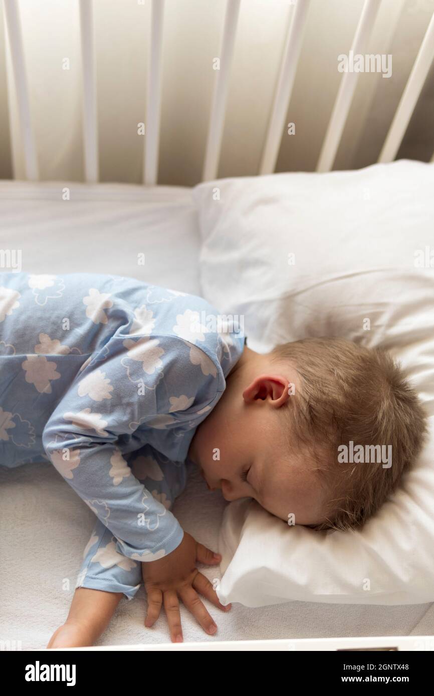 Vista dall'alto cute Little 2-3 anni prescolare bambino ragazzo bambino  dormire dolcemente in culla bianca durante il pranzo riposo in pajama blu  con cuscino a casa Foto stock - Alamy