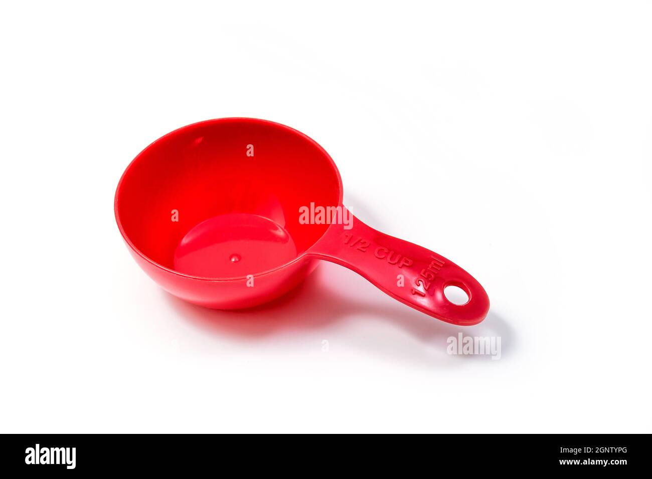 Misurino o cucchiaio per ingredienti rossi - misura metà. Isolato su sfondo bianco con tracciato di ritaglio Foto Stock
