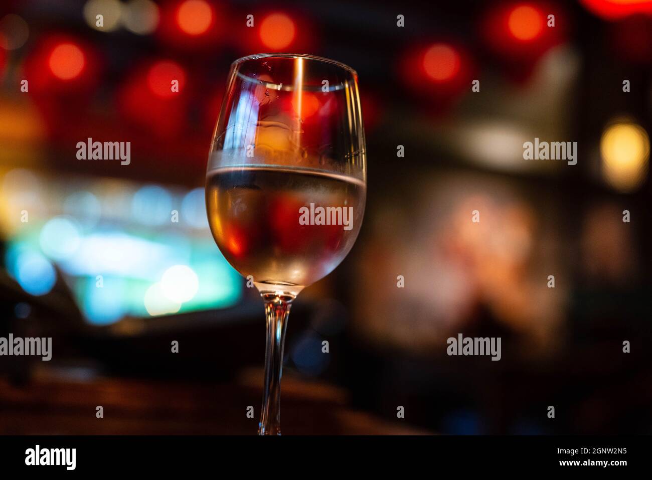 Vino rosa bianco in un ristorante con decorazioni sfocate sullo sfondo Foto Stock