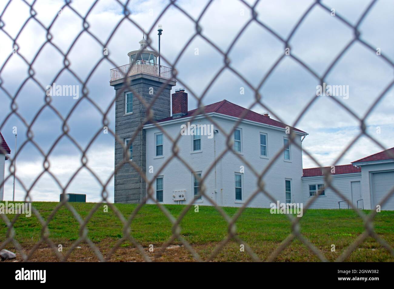 Fuoco selettivo del faro di Watch Hill a Westerly, Rhode Island, attraverso una catena di collegamento recinzione -03 Foto Stock