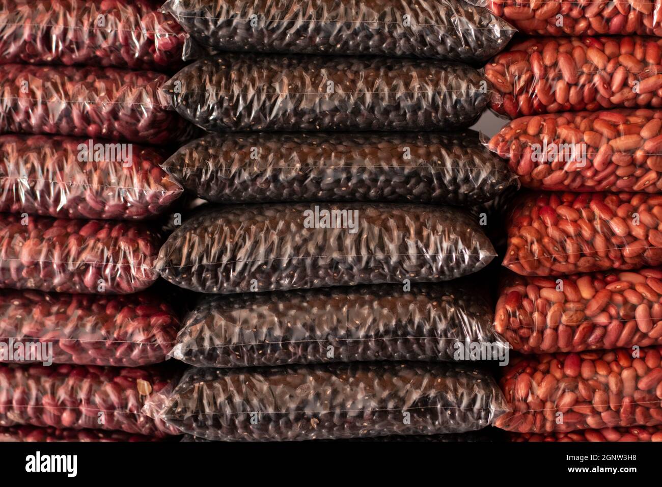 Fagioli rossi, neri e rosa impilati. Tipi diversi di fagioli. Fagioli latini. Deposito di fagioli asciutti. Foto Stock