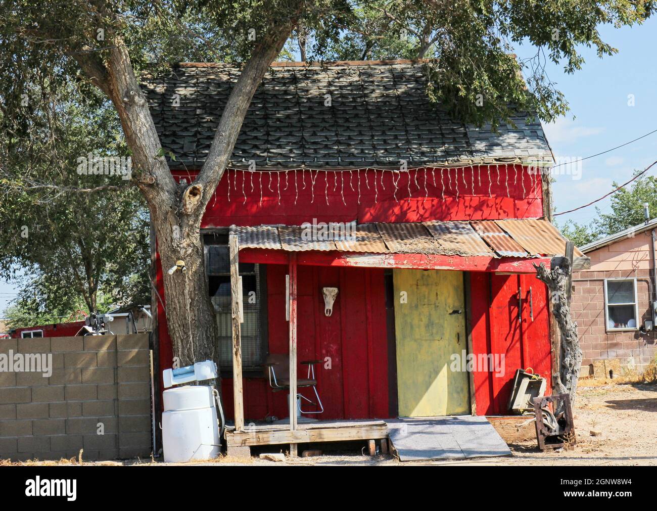Vecchia casa abbandonata con i detriti dell'appliance all'esterno Foto Stock
