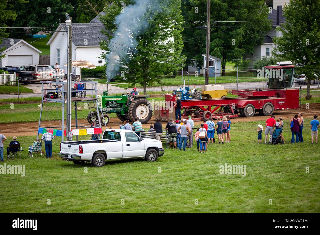 Gli spettatori si riuniscono tra un pick-up cart bianco Chevrolet e un evento di tiro al trattore al Noble County Fairgrounds di Kendallville, Indiana, USA. Foto Stock