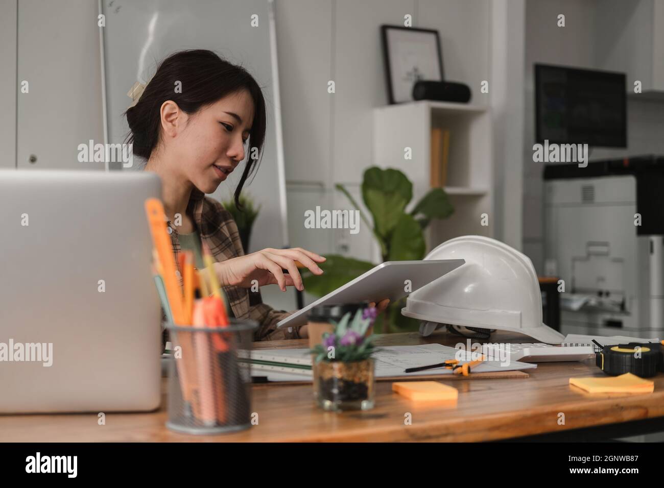 Architetto donna progettista strutturale ingegnere ufficio in cerca di tablet discutere progetto di progetto di costruzione piano. Architetto che lavora al digitale Foto Stock
