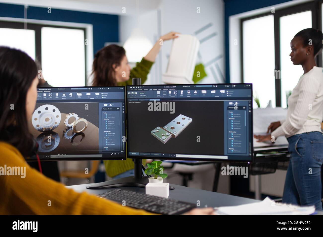 Ingegnere industriale donna che lavora al pc con due monitor, schermi che  mostrano software CAD con