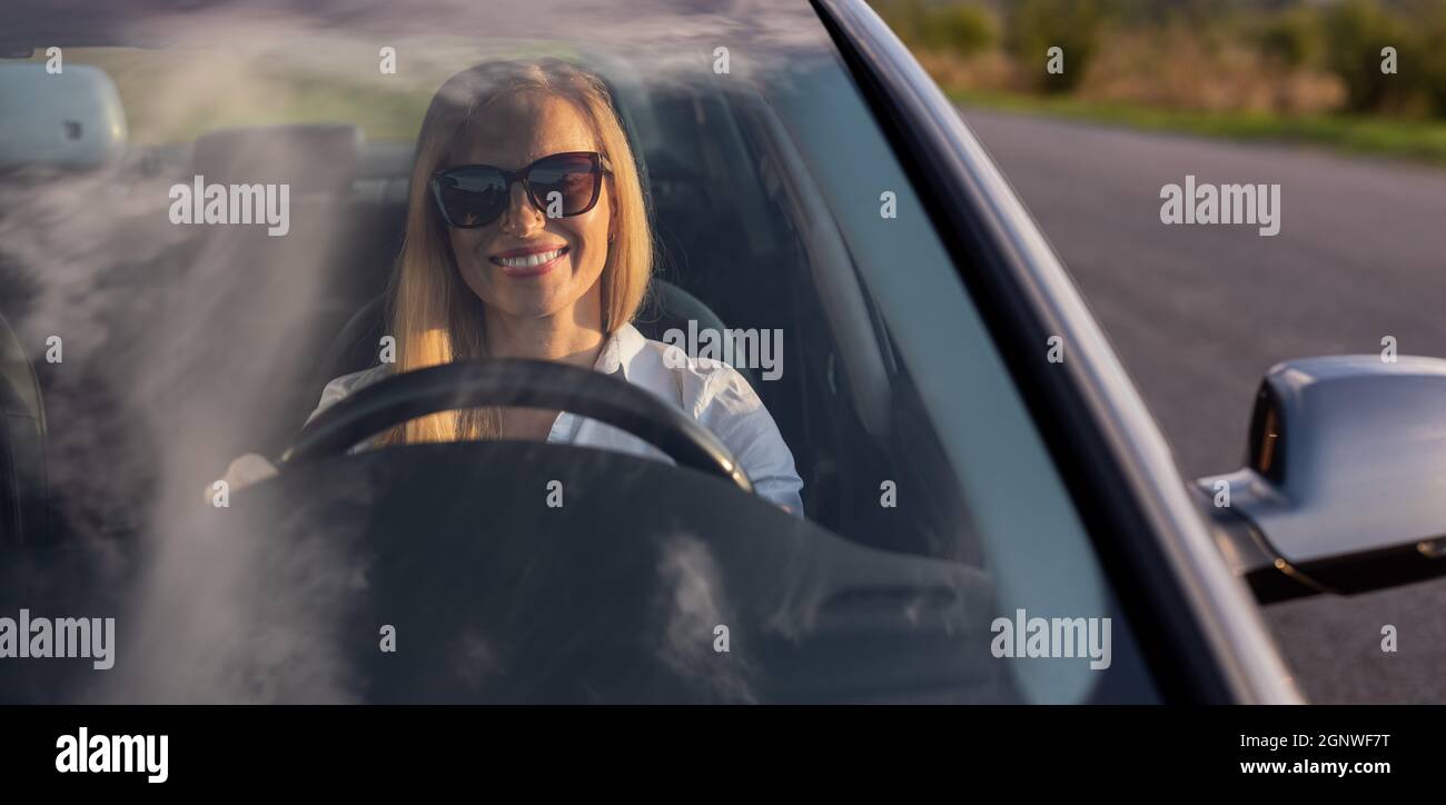 Donna sorridente auto pilotaggio Foto Stock