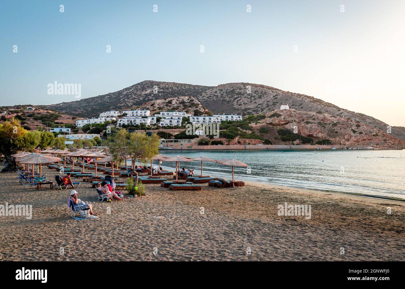 I nuotatori si godono il tramonto sulla spiaggia di Galissas, un villaggio dell'isola di Syros, a circa 5 km da Ermoupolis, la capitale dell'isola. Foto Stock