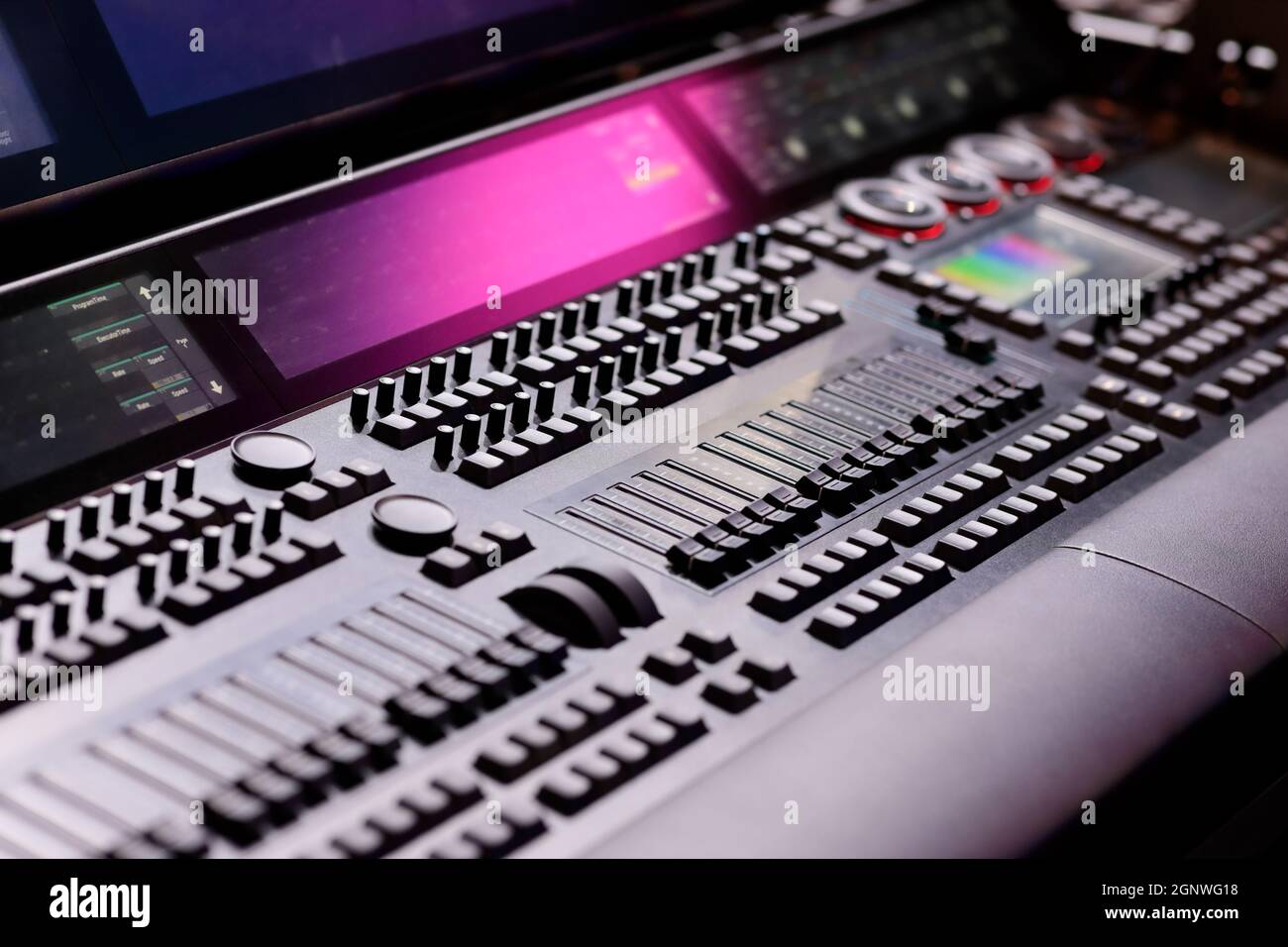 Tasti, fader, encoder e schermate sulla console di controllo illuminazione. Messa a fuoco selettiva. Foto Stock