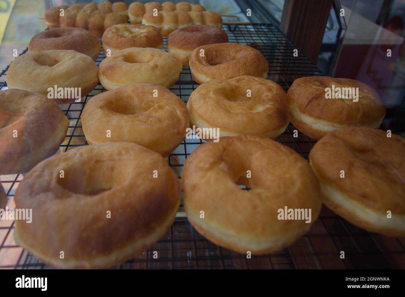 ciambelle fresche non rivestite nel vassoio da esposizione Foto Stock
