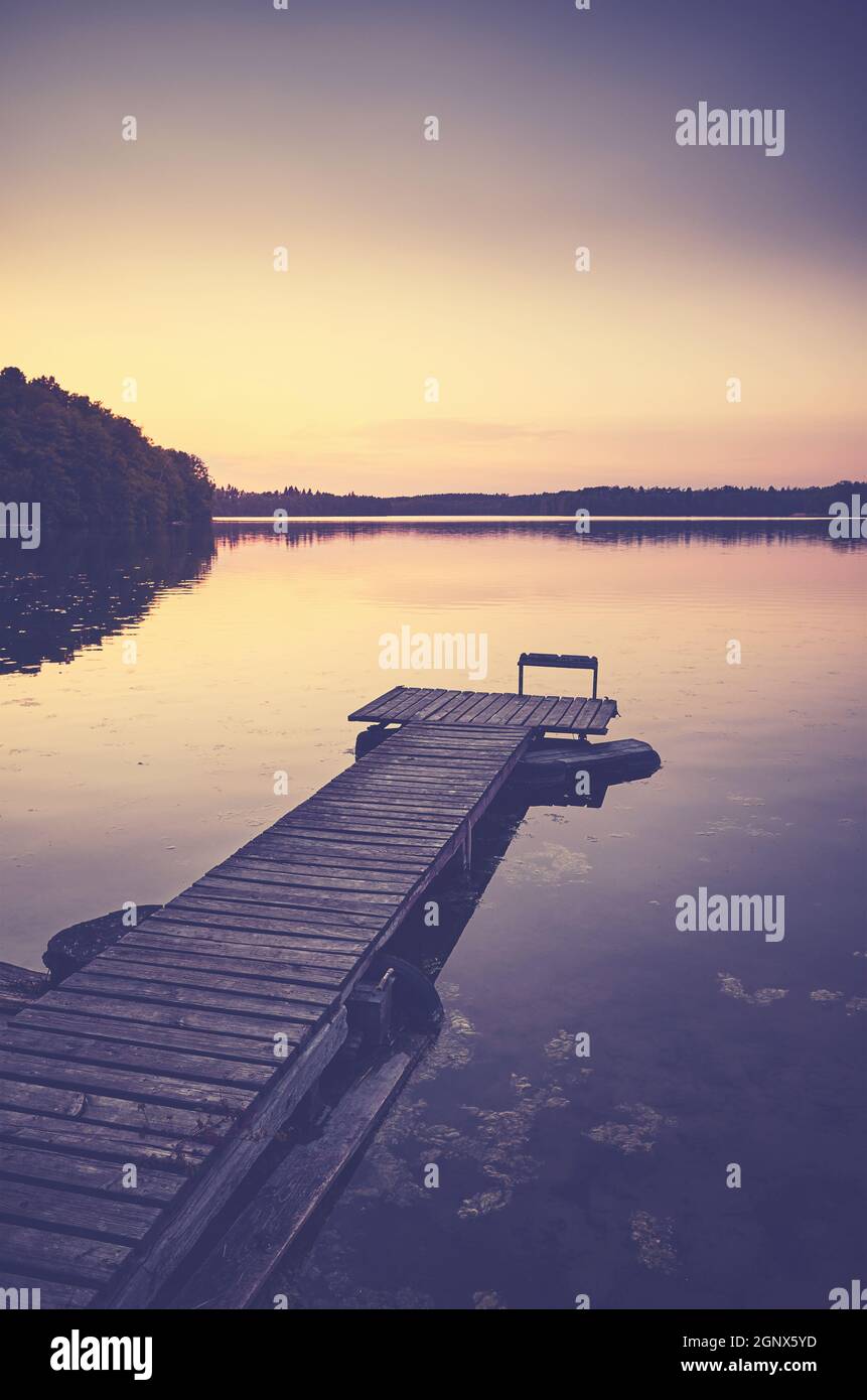 Molo lago di legno al tramonto, tonificante applicato. Foto Stock