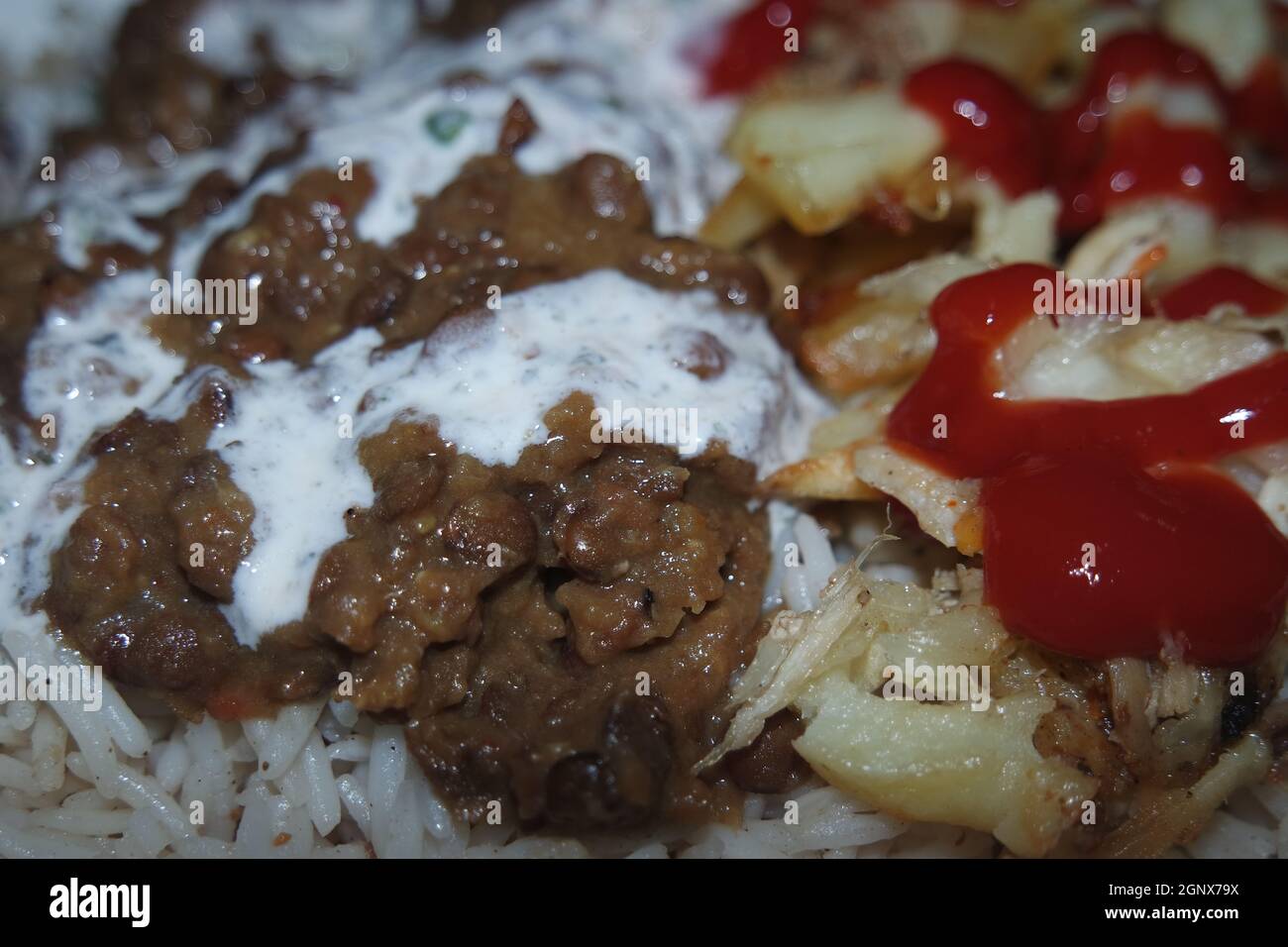 Delizioso piatto tradizionale di riso con patatine fritte e cereali con ketchup rosso. Sfondo alimentare con spazio di copia per testo e pubblicità. Foto Stock