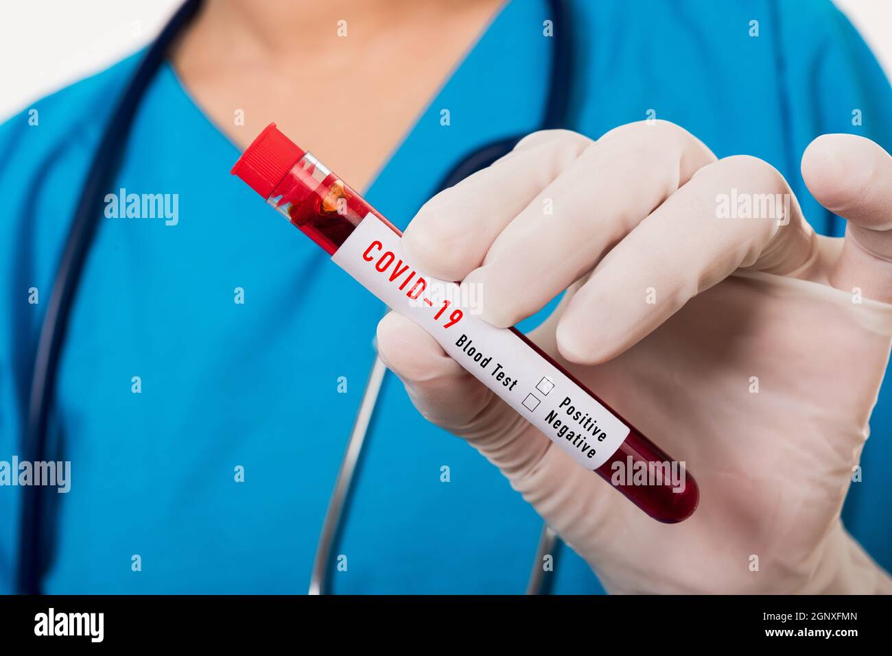 Infermiere in uniforme blu indossare una maschera contenente provetta campione Coronavirus sangue di test in laboratorio per l'analisi isolato su sfondo bianco, medici Foto Stock