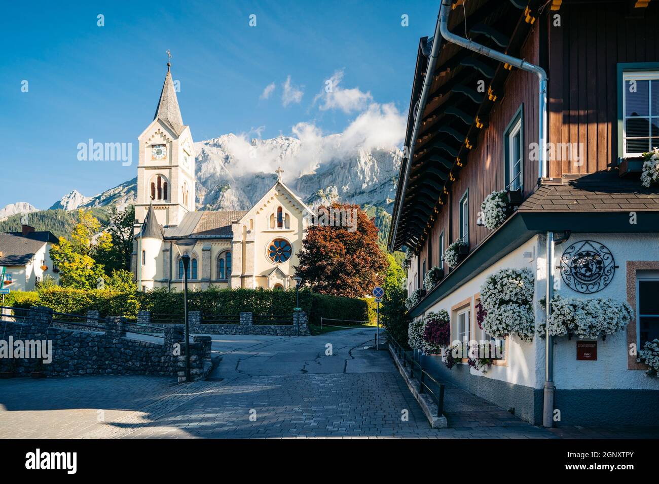 Chiesa protestante a Ramsau am Dachstein con la catena montuosa di Dachstein che torreggia sul retro, in Austria Foto Stock
