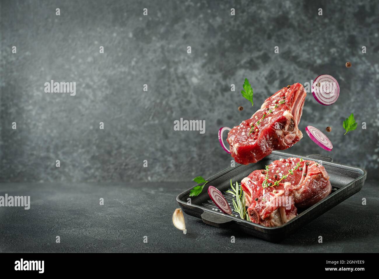 Bistecca di vitello che vola sulla padella del grill su sfondo scuro.  Spazio di copia Foto stock - Alamy