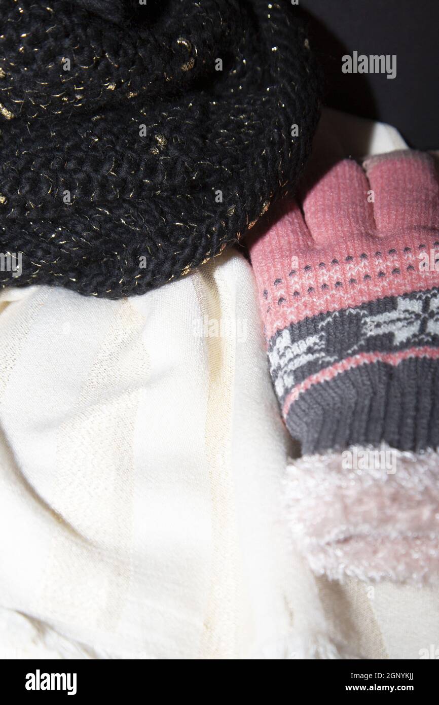 Sciarpa bianca e dorata, cappello invernale nero e oro, guanti invernali  rosa e grigi Foto stock - Alamy