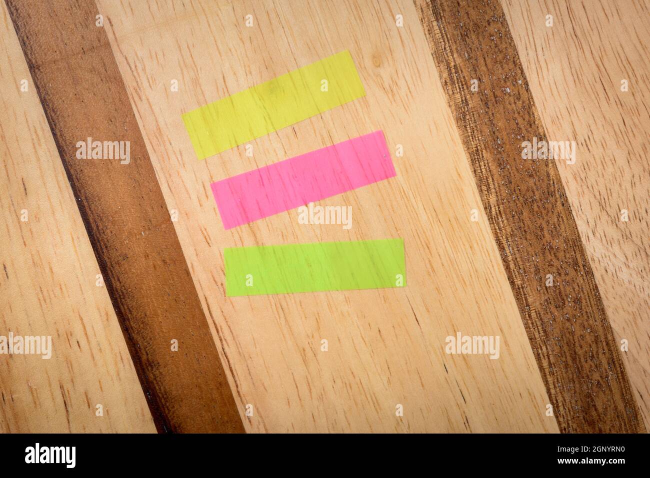 Note tre colori orizzontali mix su uno sfondo di legno Foto Stock