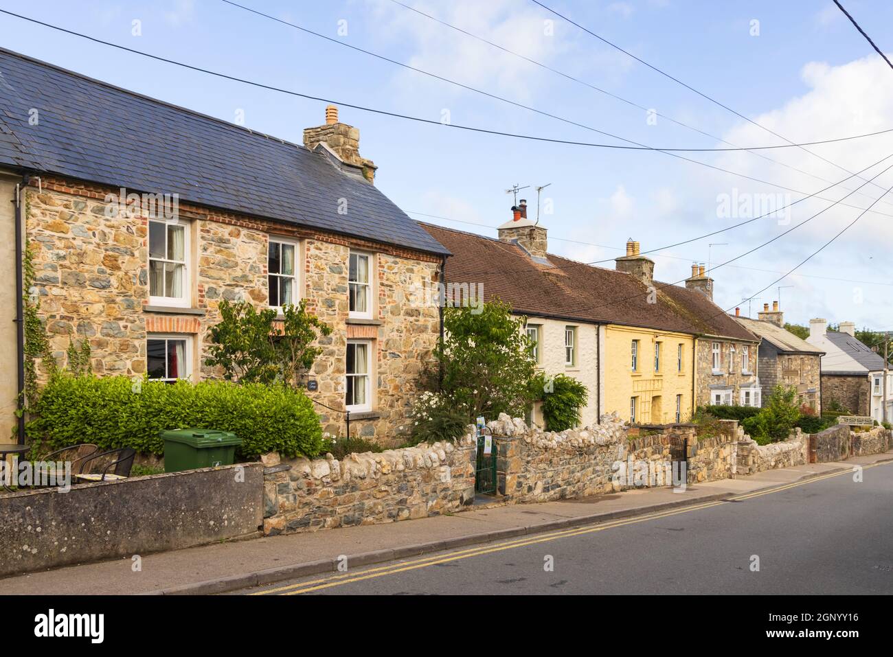 Fila di attraenti cottage in pietra gallese a Long Street, Newport, Pembrokeshire. Galles, Regno Unito Foto Stock