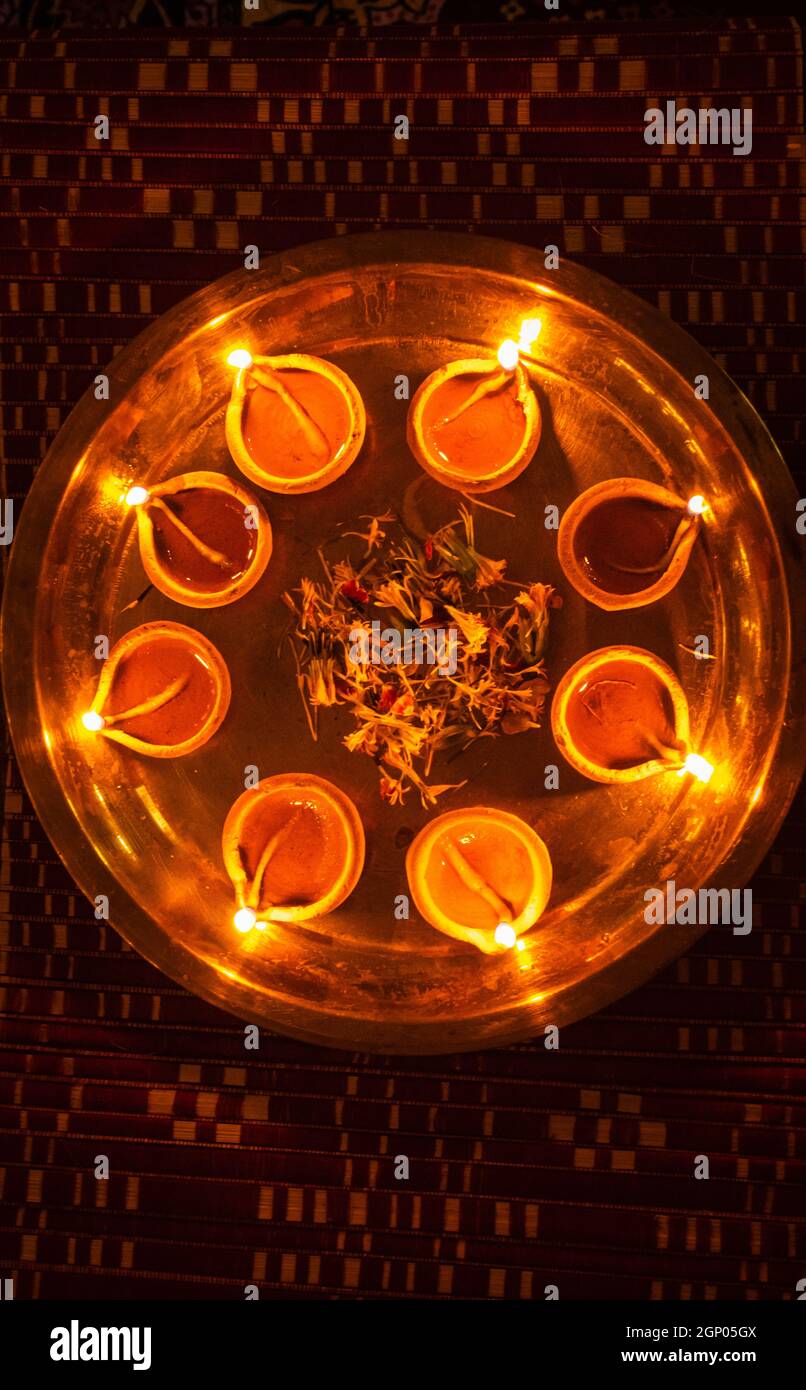 lampade ad olio di argilla illuminate con petali di fiori tenuti in plat per le luci della celebrazione culturale diwali Foto Stock