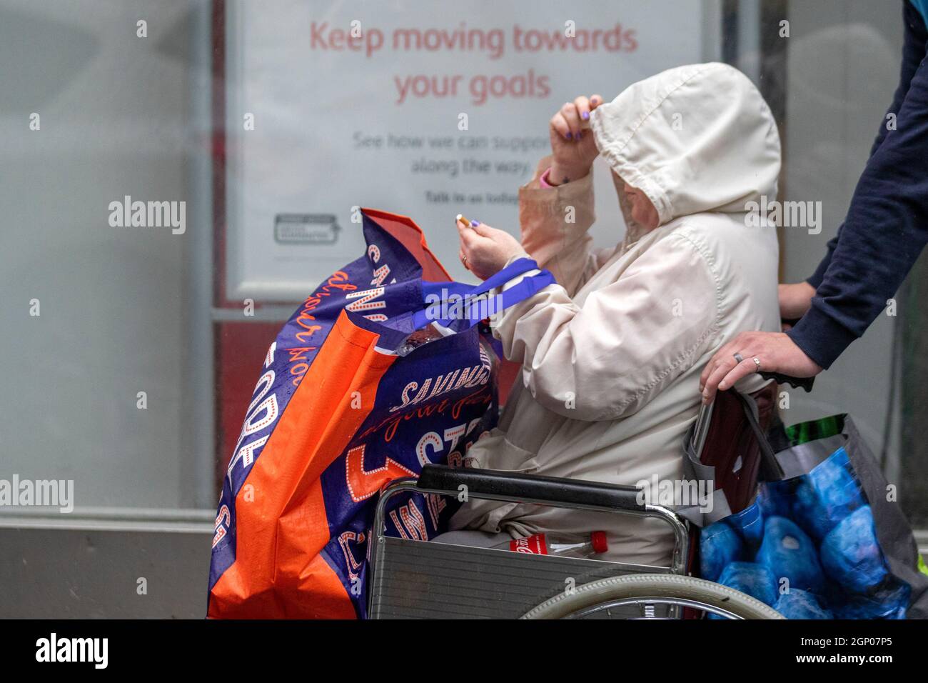 Southport, Merseyside, UK Weather; 28 settembre 2021. Negozi, negozi per disabili che fanno shopping in una giornata di vento umido e bluasty nel centro della città nord-occidentale. Credit: MediaWorldImages/AlamyLiveNews Foto Stock