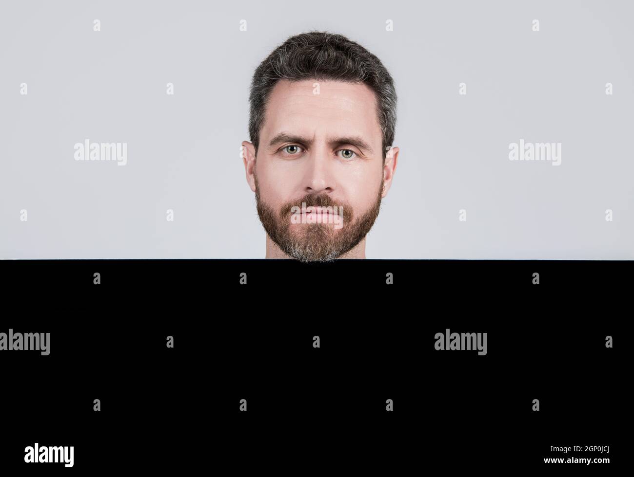 uomo maturo bearded dietro il banner bianco di carta nera con spazio di copia per la promozione, pubblicità Foto Stock