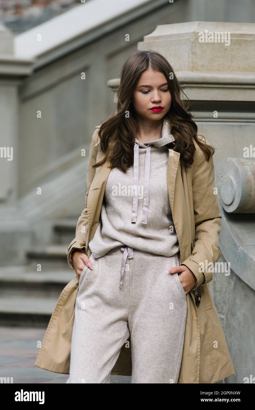 Ritratto di donne alla moda in tuta sportiva beige e trench in posa per  strada Foto stock - Alamy