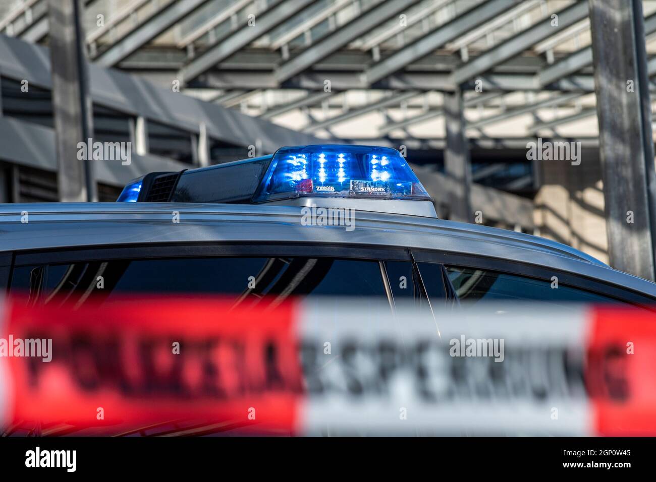 ILLUSTRAZIONE - 28 settembre 2021, Renania settentrionale-Vestfalia, Gütersloh: Un nastro di barriera con l'iscrizione 'barriera di polizia' è teso di fronte ad una macchina di polizia. Foto: David Inderlied/dpa Foto Stock