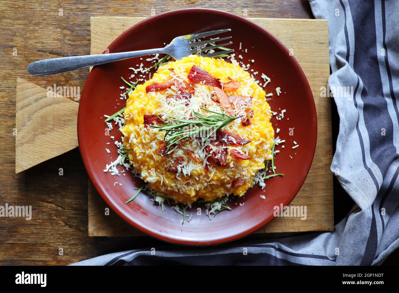 Risotto con zucca e pancetta su un tavolo di legno scuro. Vista dall'alto Foto Stock