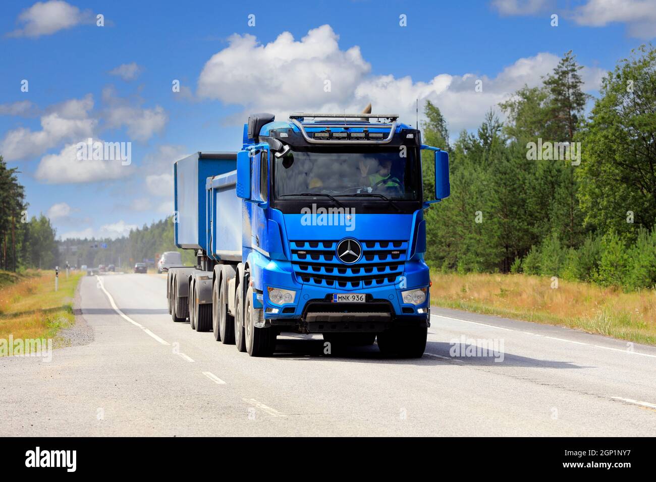 Blue Mercedes-Benz Arocs ghiaia camion e cassetta rimorchio di Hänninen Gruppo Oy su strada in bella giornata d'estate. Raasepori, Finlandia. 8 luglio 2021. Foto Stock