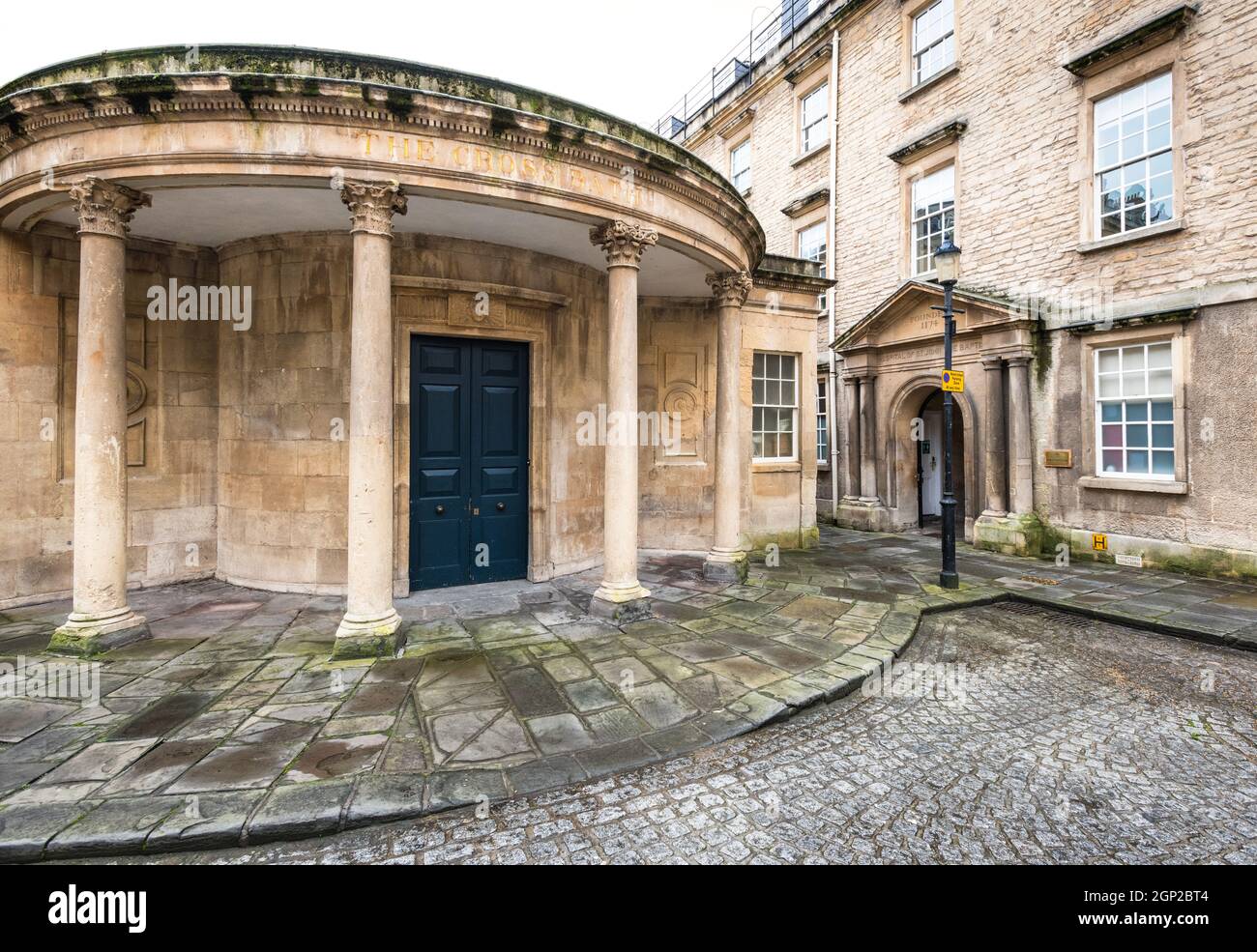 Il Cross Bath, una storica piscina per il bagno, con l'ingresso all'Ospedale di San Giovanni Battista sulla destra, Bath, Somerset, Inghilterra Foto Stock