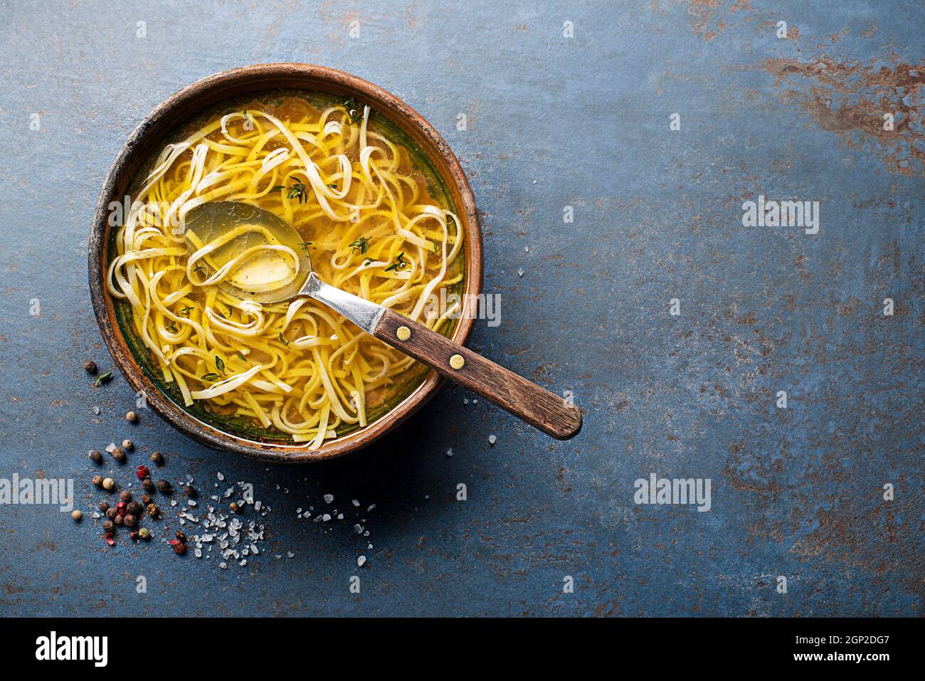 Gustosa zuppa di brodo di carne con erbe e tagliatelle in un primo piano della ciotola Foto Stock