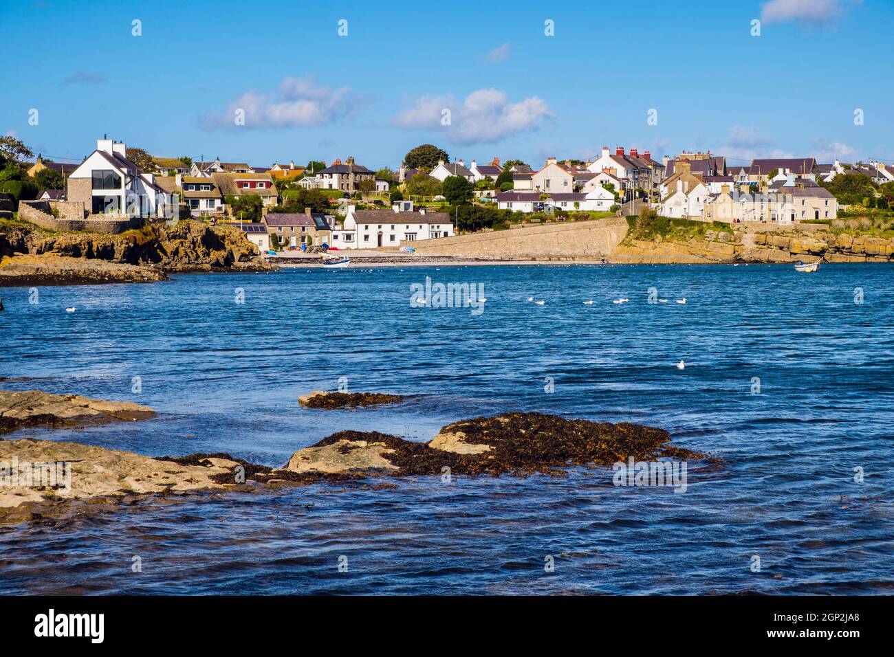 Vista sul mare fino al lungomare del villaggio e alla piccola spiaggia. Moelfre, isola di Anglesey, Galles del nord, Regno Unito, Gran Bretagna, Europa Foto Stock