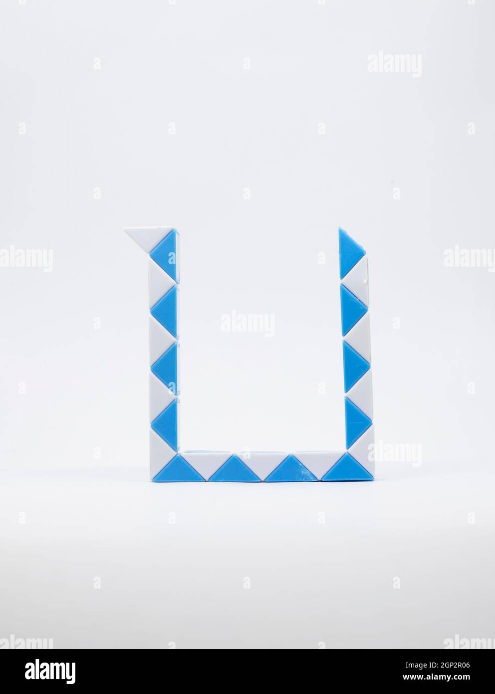 Lettera 'u' fatta di triangoli bianchi e blu su sfondo bianco. Foto Stock