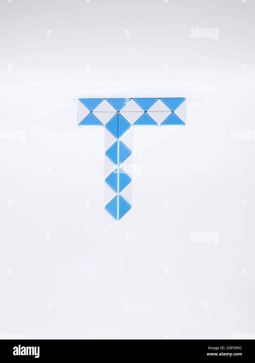 Lettera 't' fatta di triangoli blu e bianchi su sfondo bianco. Foto Stock