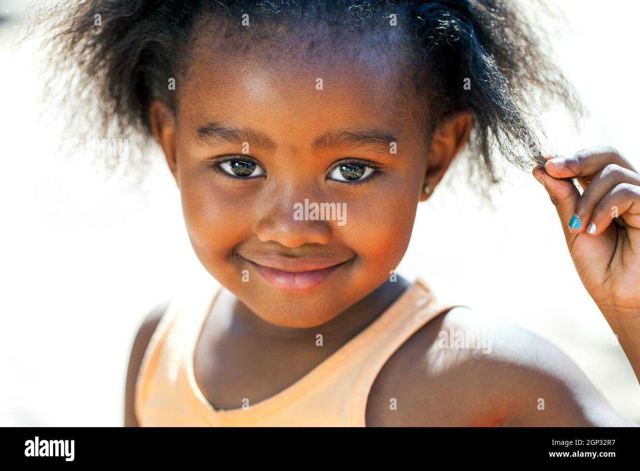 Close up faccia colpo di carino ragazza africana di toccare i capelli. Foto Stock