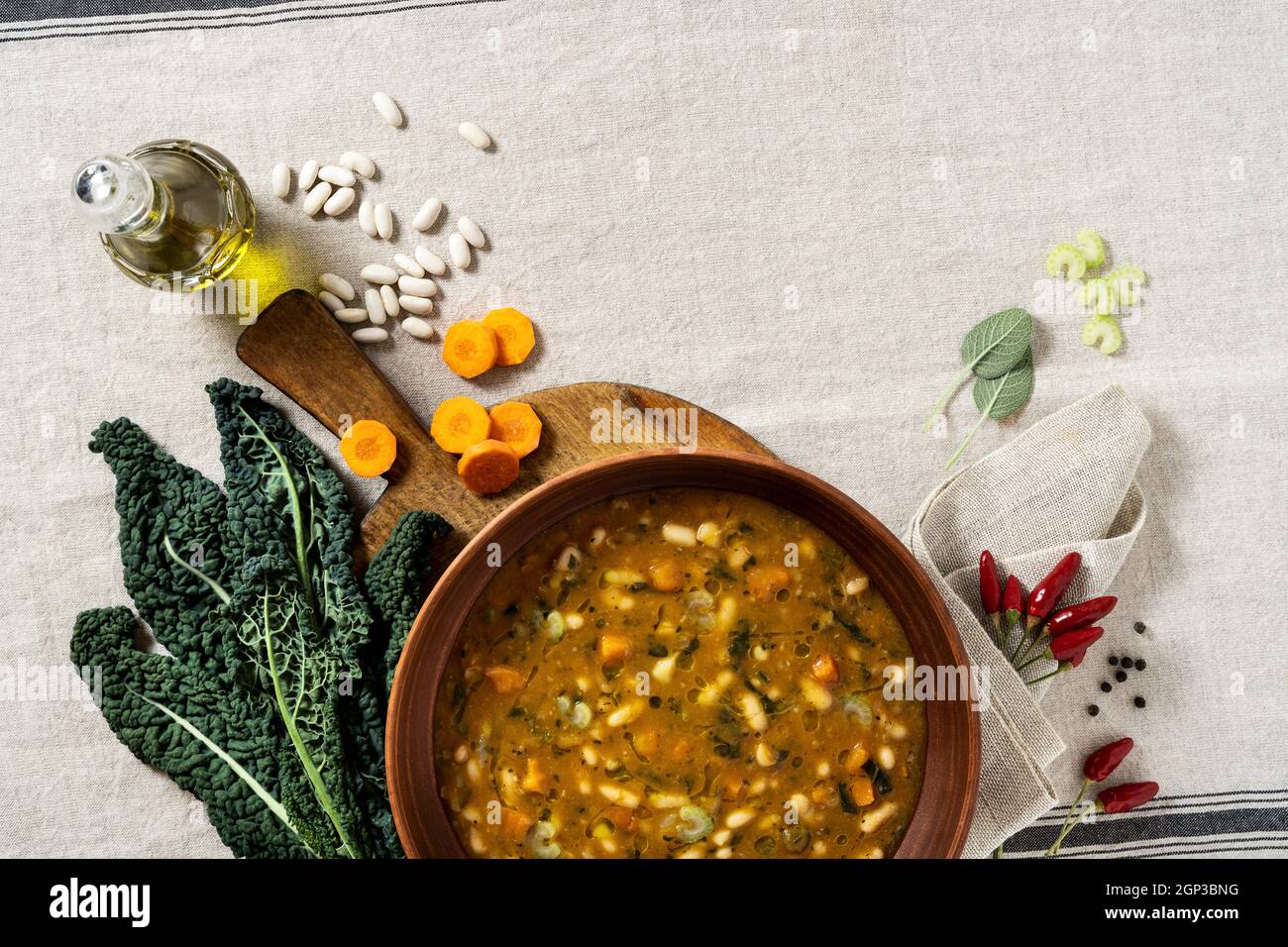 Minestrone italiano con verdure e fagioli su un tavolo con tovaglia di lino Foto Stock