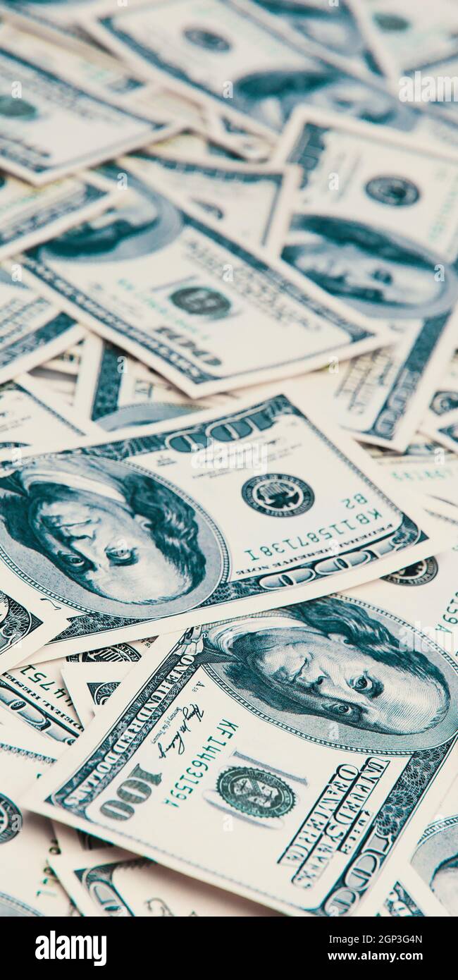 Un centinaio di banconote americane sono sparse, banconote da cento dollari in contanti, immagine di fondo del dollaro. Foto Stock