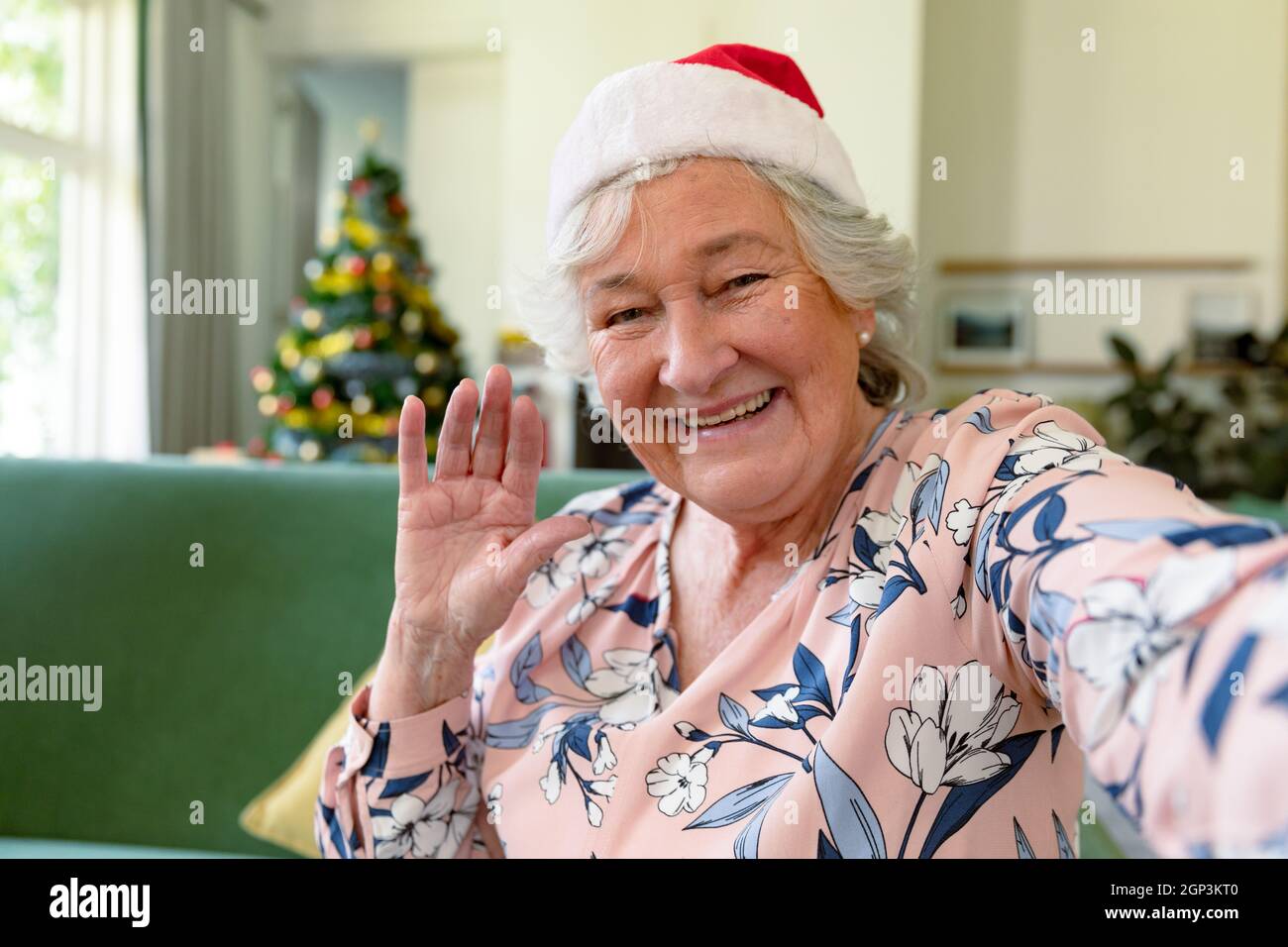 Felice donna caucasica anziana che indossa santa Hat con videochiamata a natale Foto Stock