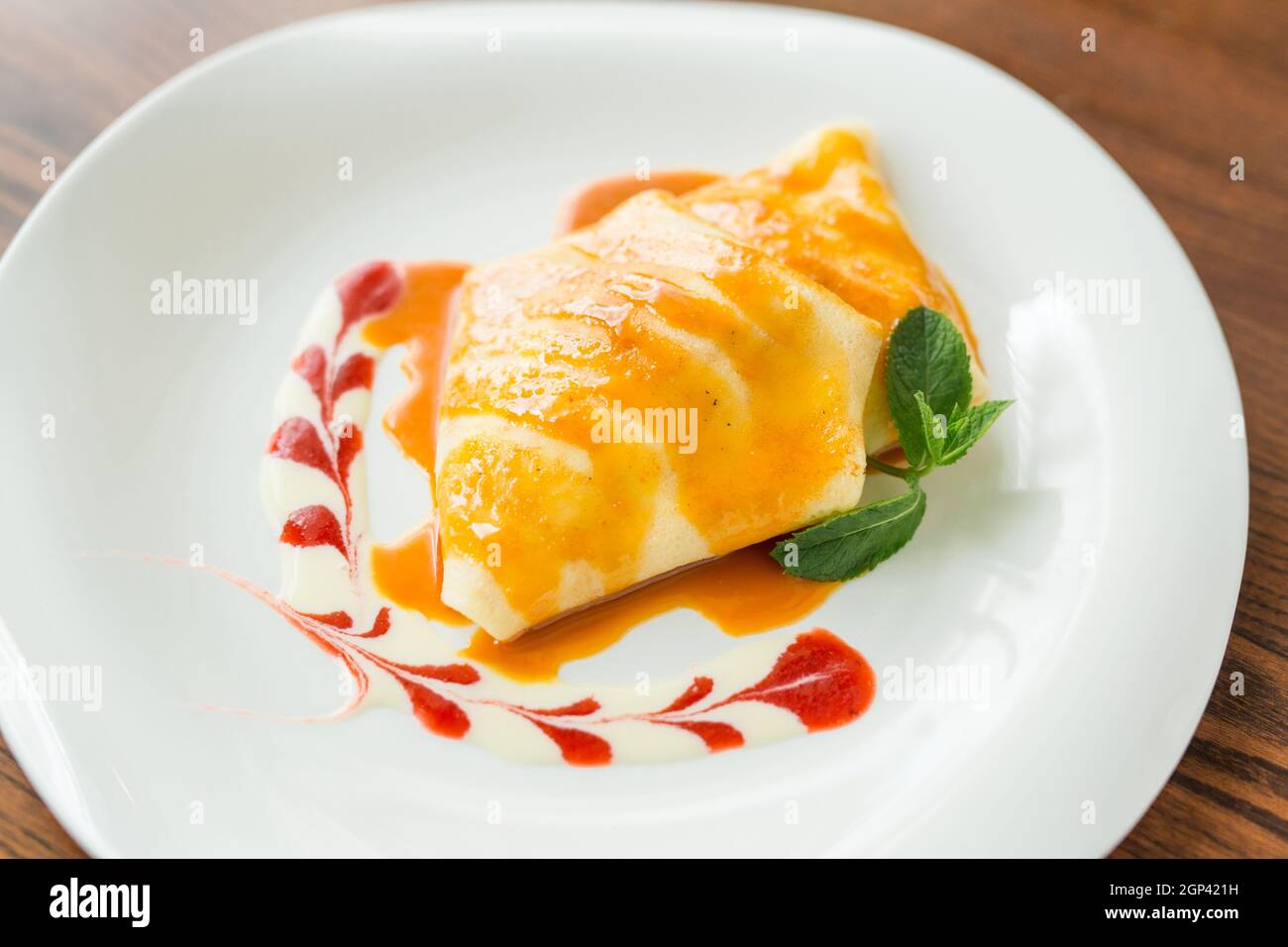 alcuni pancake da dessert con marmellata di fragole, miele e un cucchiaio bianco di gelato. Concetto - menu per un caffè Foto Stock