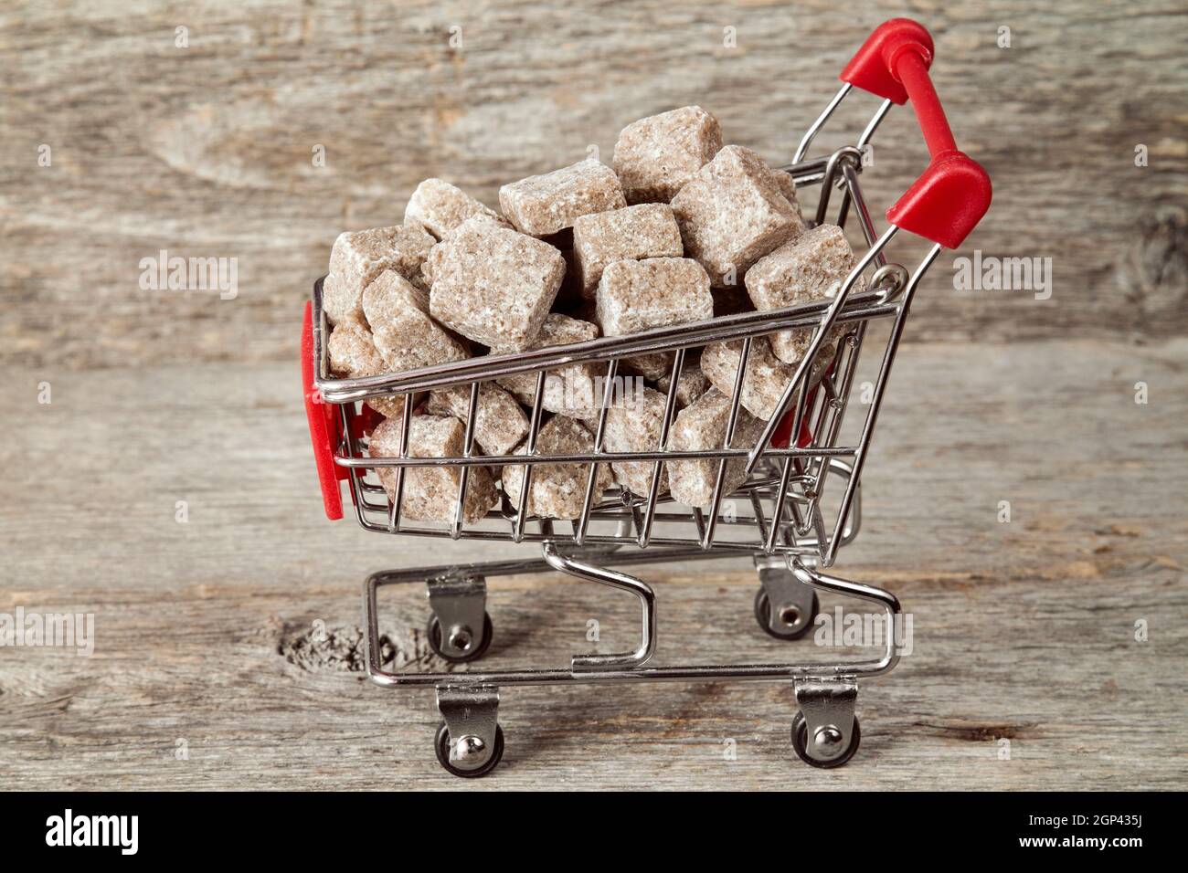 Carrello pieno di colore marrone zucchero di canna su sfondo di legno Foto Stock