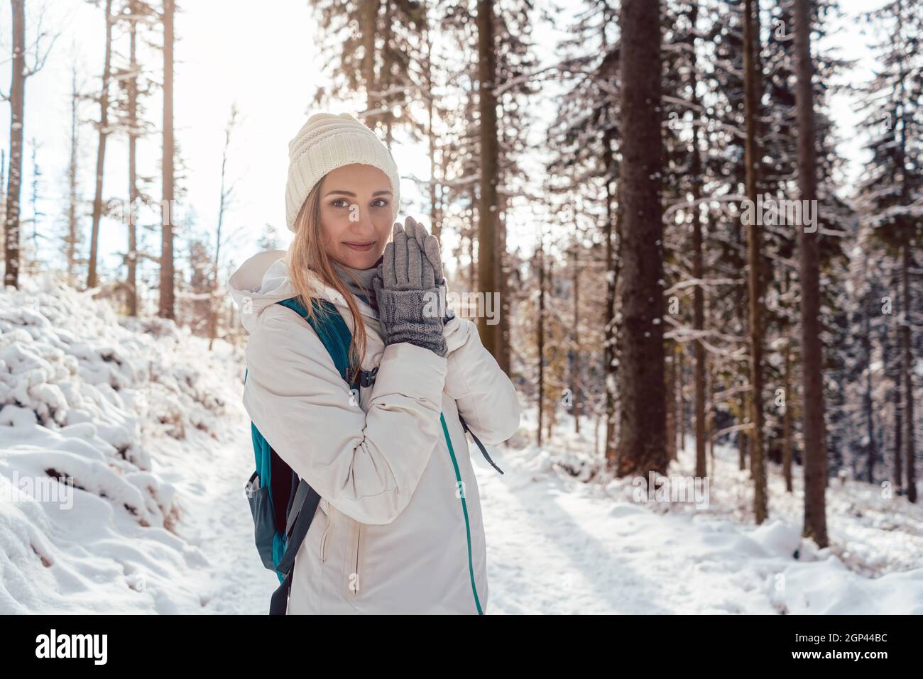 Donna godendo la sua escursione invernale godendo il tramonto nella foresta Foto Stock