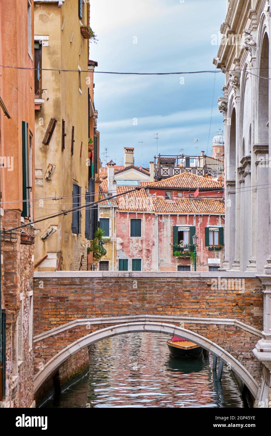 Vista su una stretta via navigabile e ponte a Venezia Foto Stock