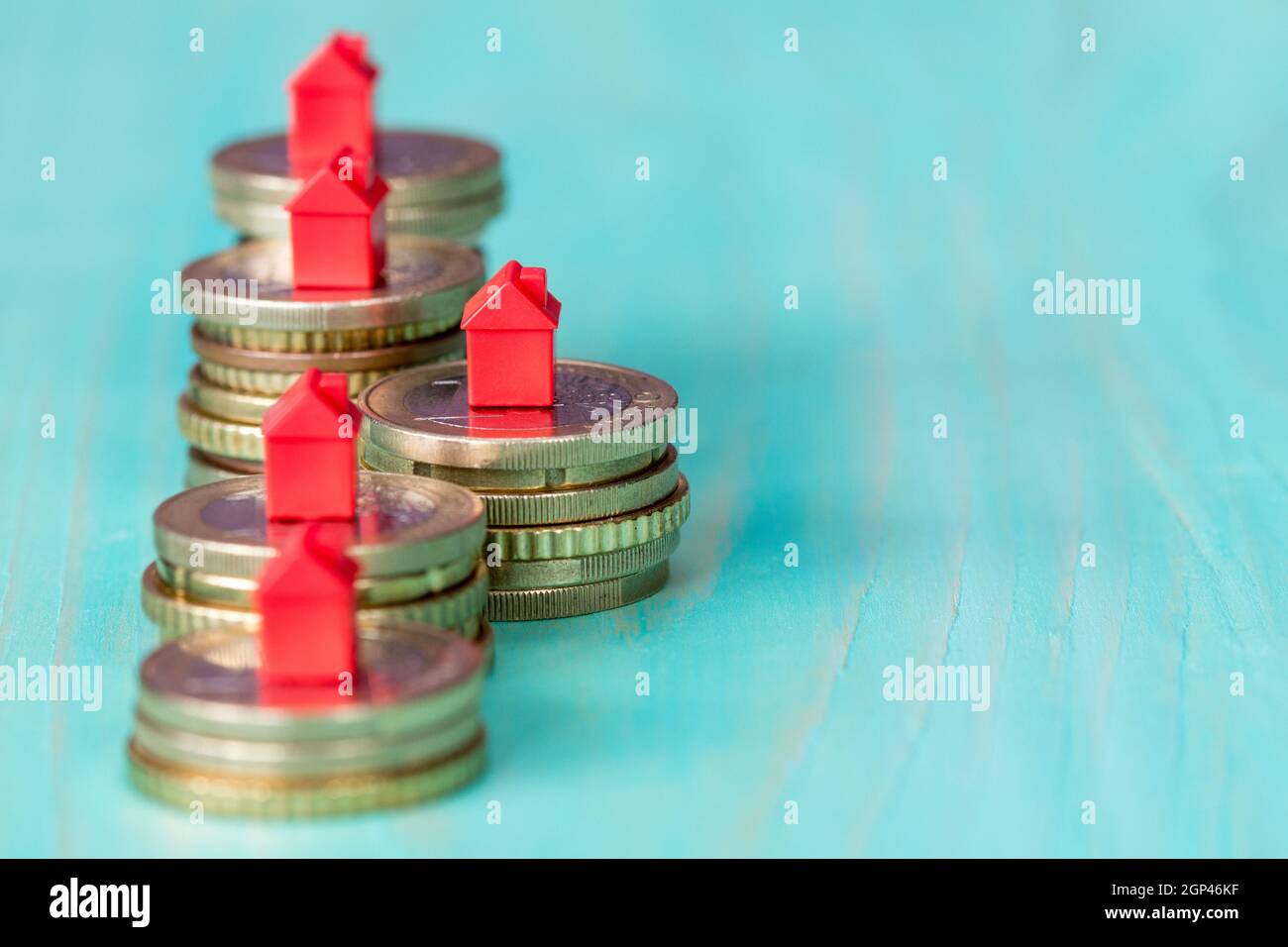 Ipoteca immobiliare concetto con piccoli modelli della casa sulla fila di monete Foto Stock