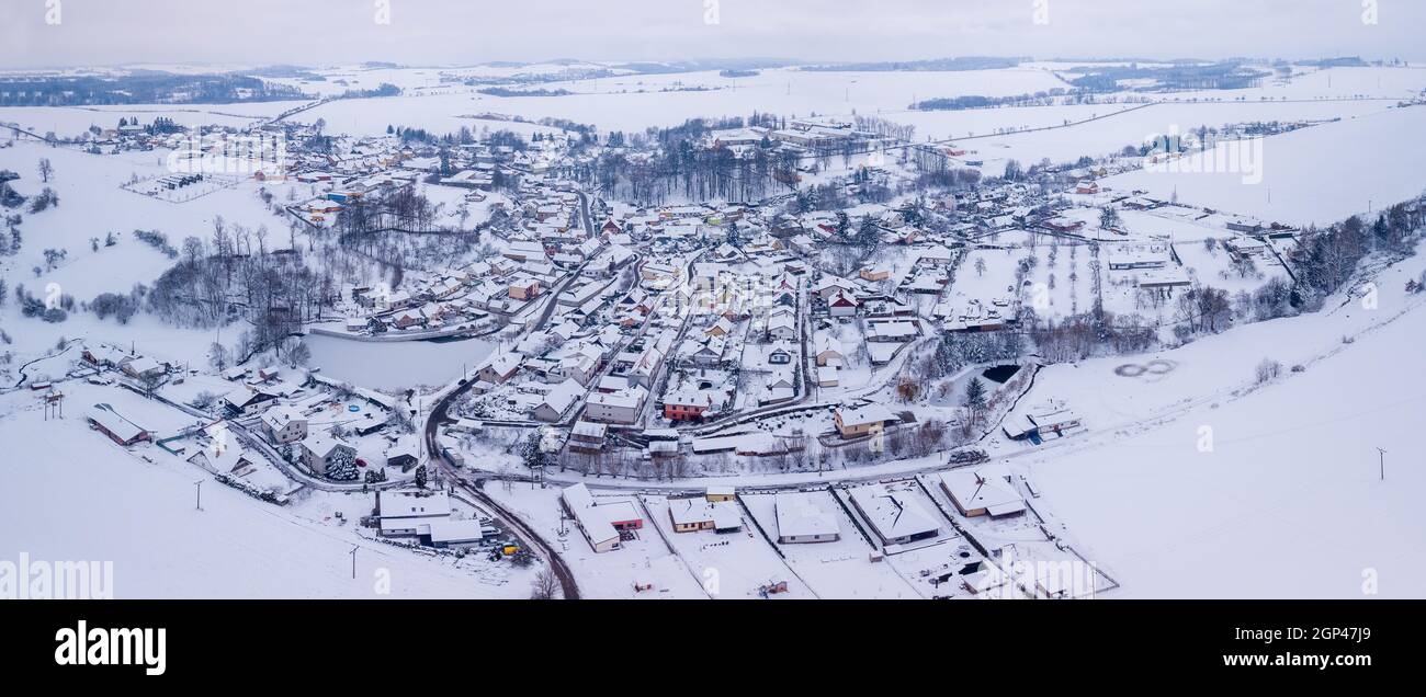 Vista aerea del villaggio Puklice con edifici residenziali in inverno. Paesaggio invernale campi innevati e alberi in campagna. Repubblica Ceca Alto Foto Stock