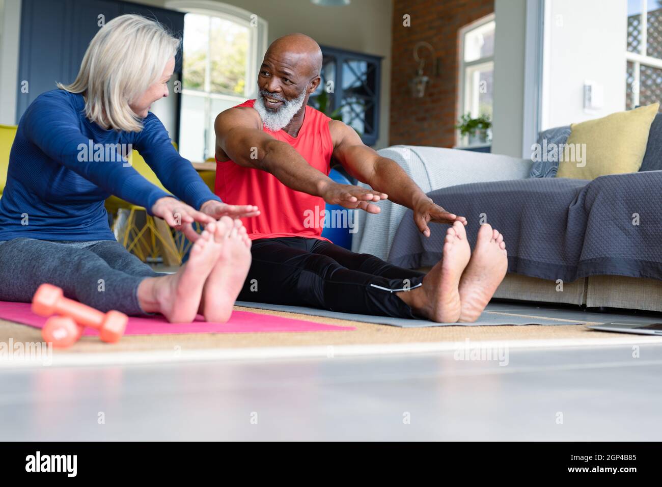 Coppia anziana felice in vestiti di esercitazione che praticano lo yoga insieme, stretching Foto Stock