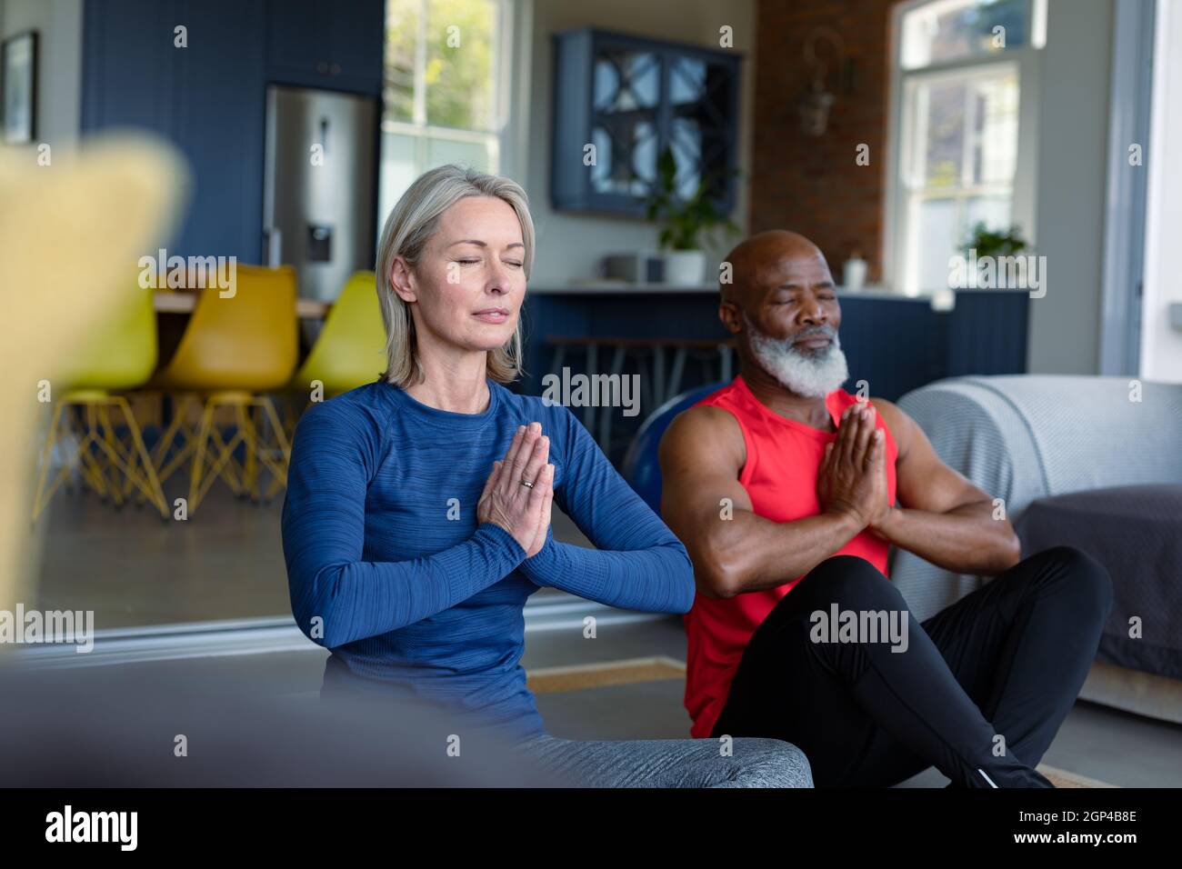 Coppia anziana felice in vestiti di esercitazione che praticano lo yoga insieme, meditating Foto Stock