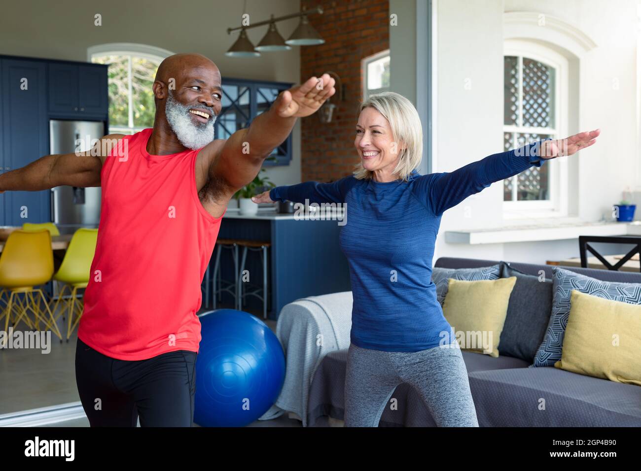 Coppia anziana felice in vestiti di esercitazione che praticano lo yoga insieme, stretching Foto Stock