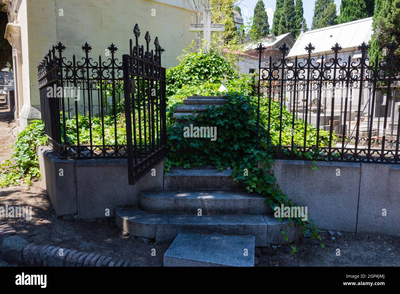 Madrid, Spagna; 6 giugno 2021: Terreno mortuario con cannella a porta aperta e creepers che lo occupano il vecchio cimitero di San Isidro a Madrid, Spagna. Concetto Foto Stock
